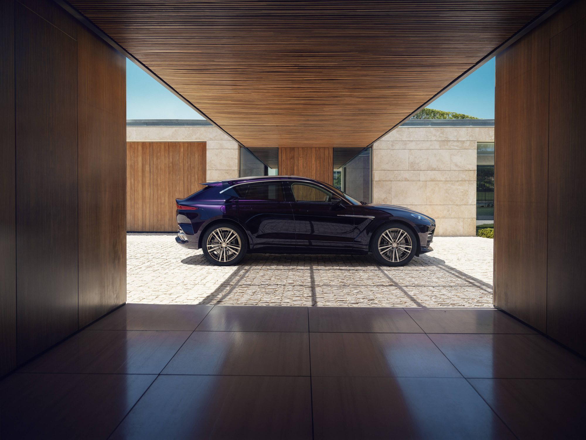 Perfil del Aston Martin DBX GT dentro de un pasaje de madera
