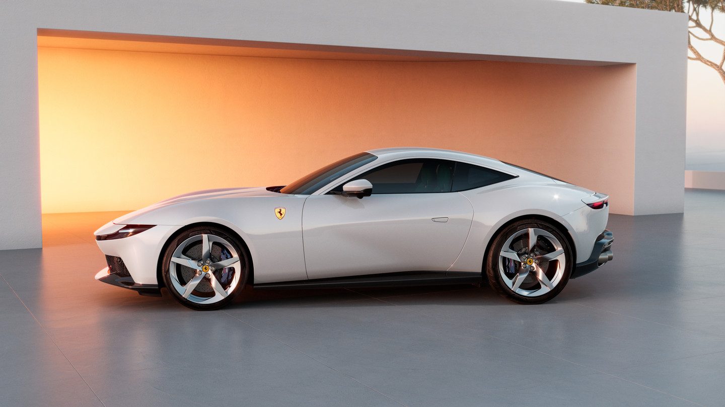 Ferrari Amalfi blanco de perfil frente a un muro iluminado al atardecer
