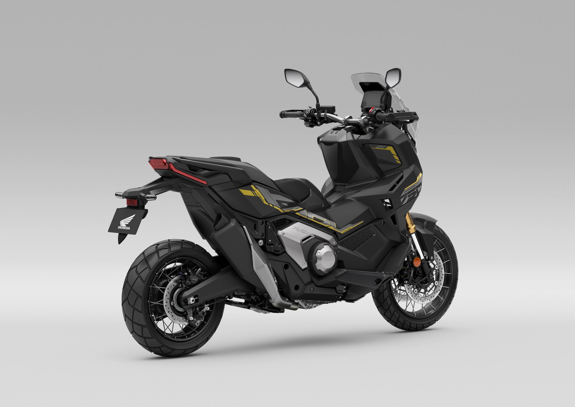 Honda X-ADV 2027 negra con detalles dorados, vista trasera de tres cuartos