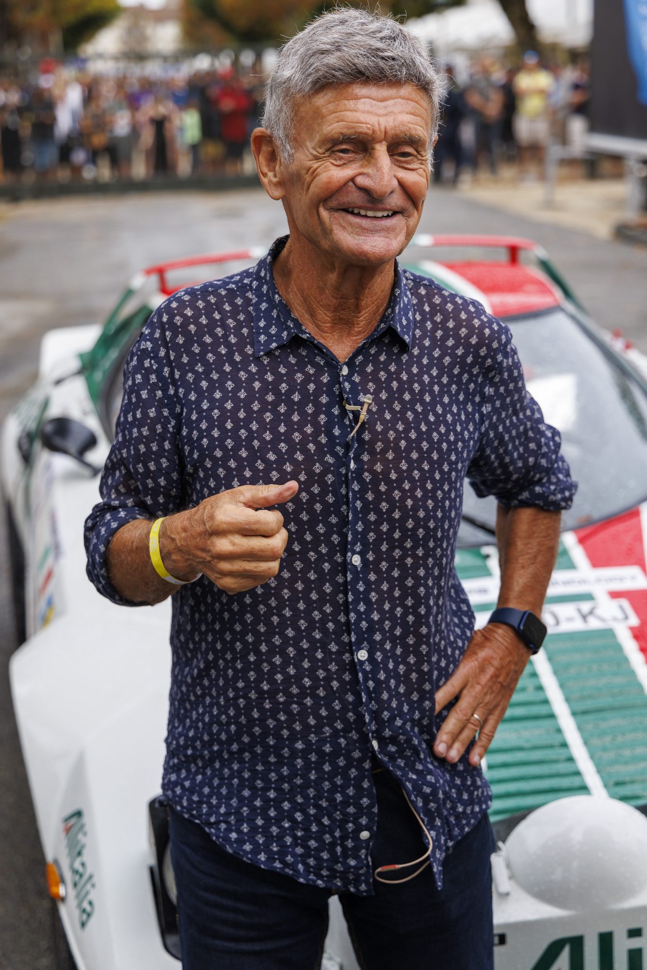 Hombre sonriente junto a un Lancia Stratos con decoración Alitalia