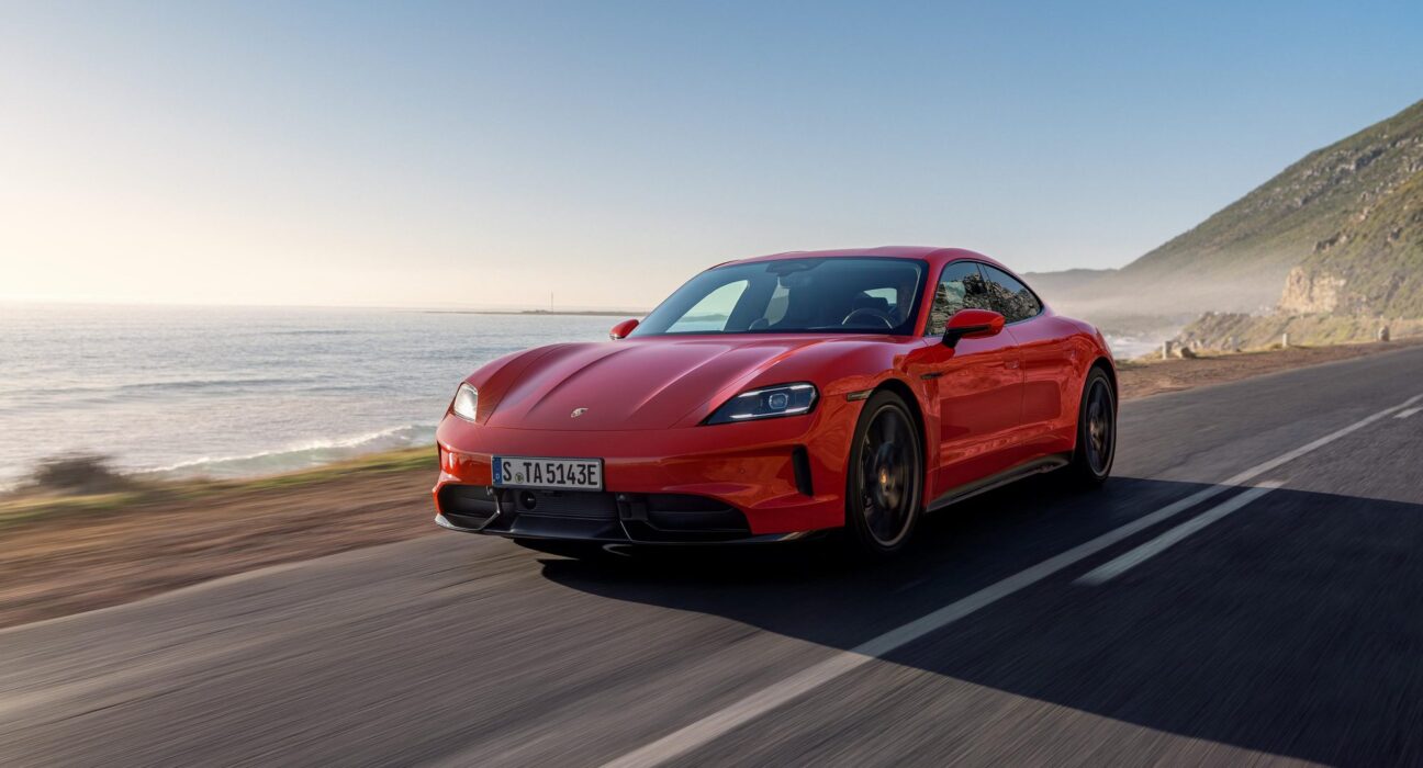 Porsche Taycan rojo circulando por una carretera costera