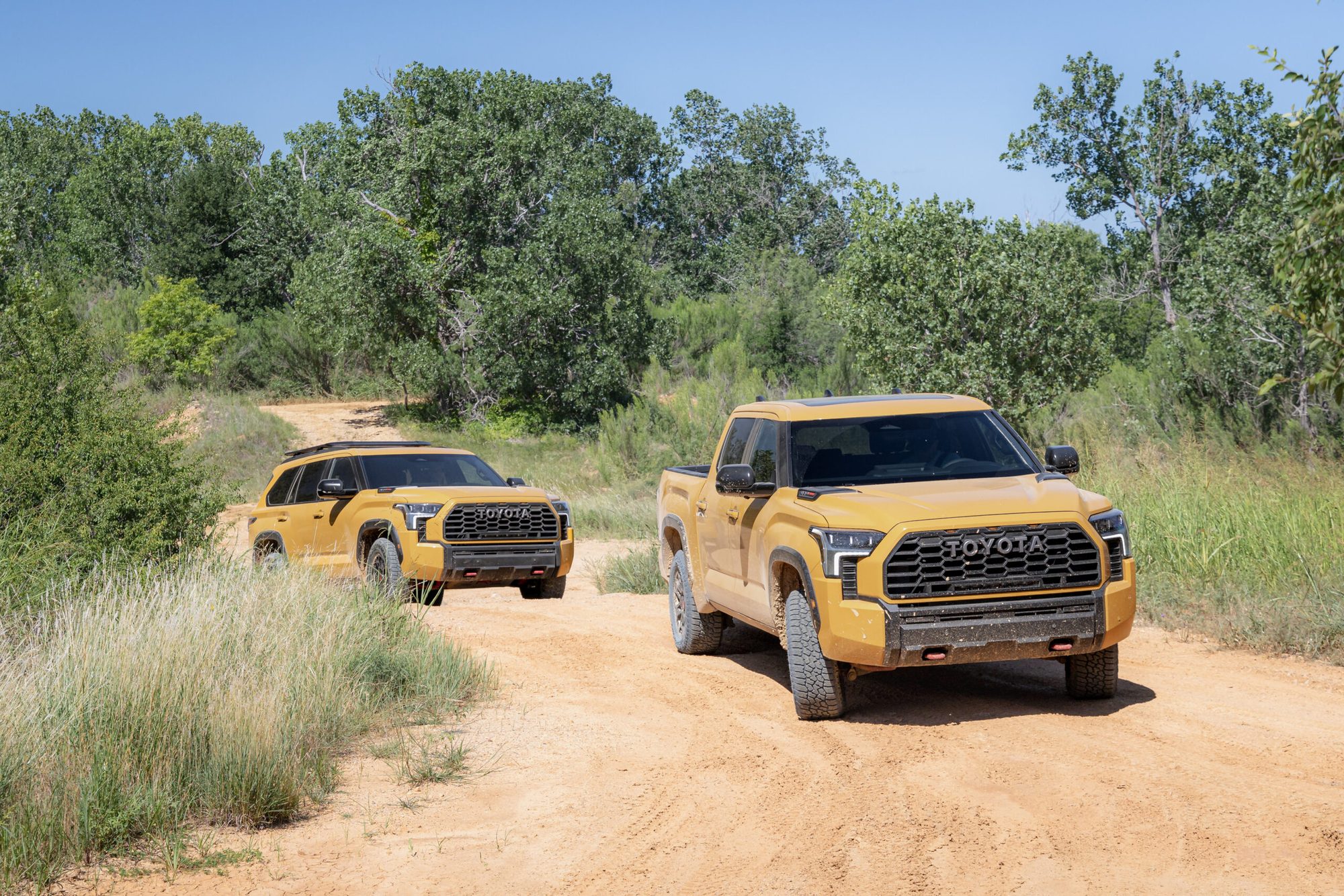 Vehículos Toyota TRD Pro color naranja en un camino de tierra