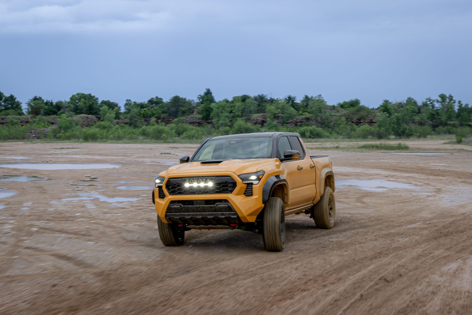 Toyota Tacoma TRD Pro 2027 en tres cuartos frontal sobre tierra mojada